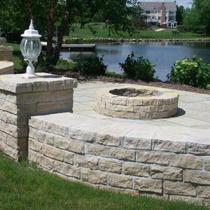 OUTDOOR LANDSCAPE DESIGN OF UNILOCK PAVERS WITH FIRE PIT AND SEAT WALL AND PILLARS