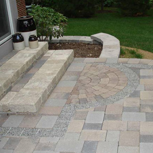 outdoor backyard patio with unilock pavers with unique design near steps