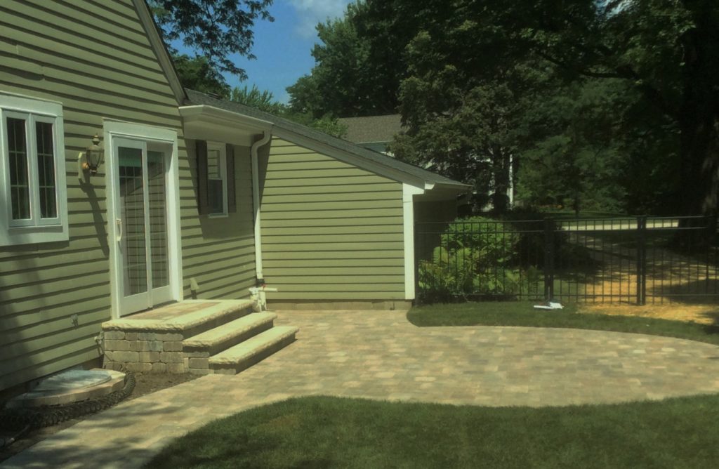 BACKYARD PAVER PATIO WITH STEPS FROM THE BACKDOOR WITH COPSTONE